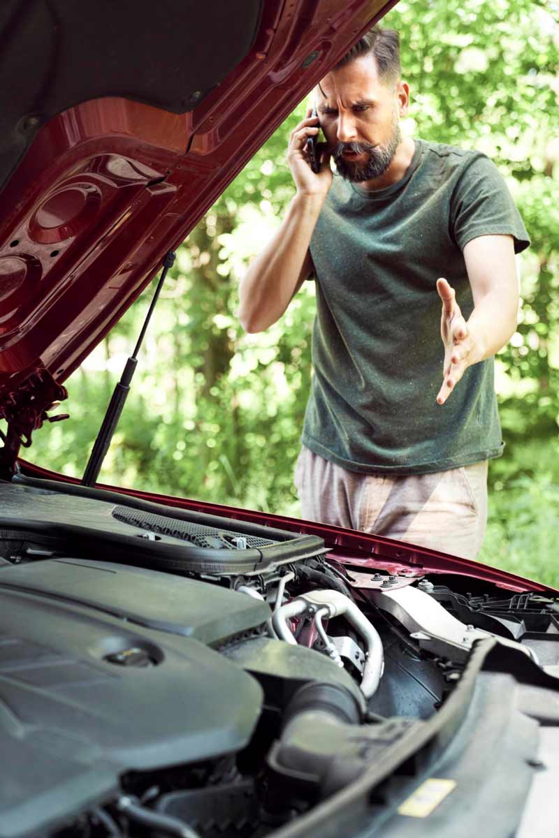 Junger Mann prüft Getriebeschaden bei Schrottauto Ankauf Koblenz
